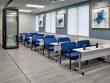 conference room with a row of white tables, blue chairs, and abstract blue artwork on the walls